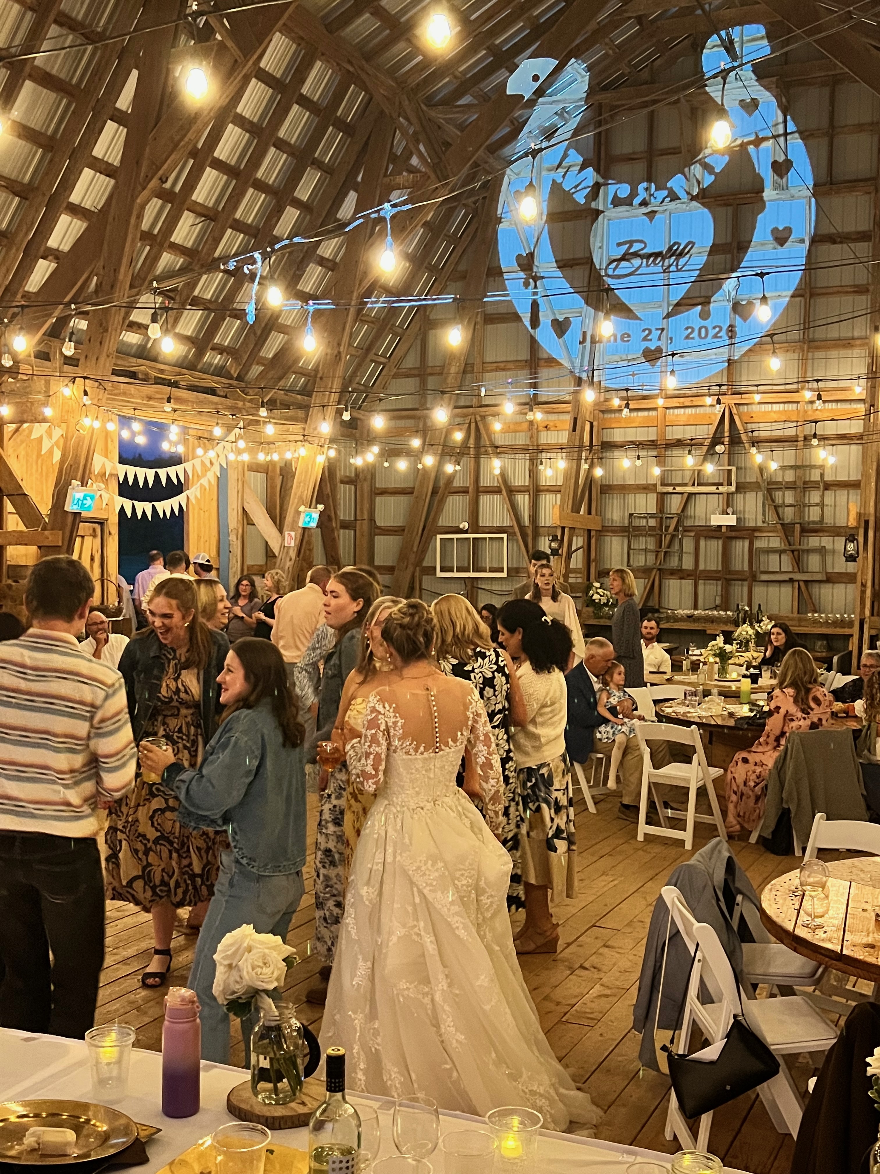 Custom wedding monogram projected inside a rustic barn reception